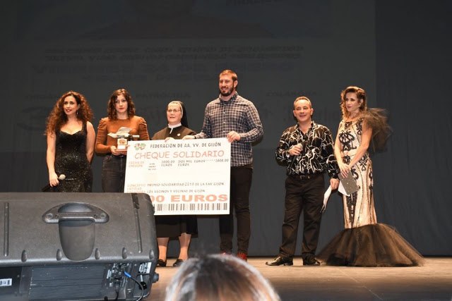 Entrega del cheque solidario de dos mil euros de la Federación de AA. VV. de Gijón, con la superiora de la casa en el escenario