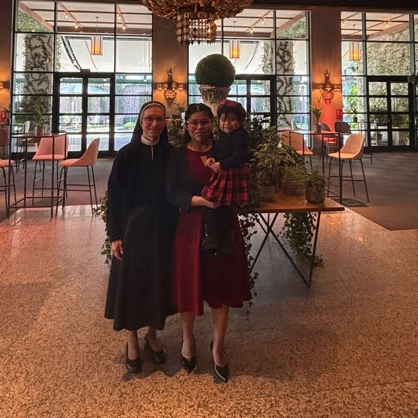 Una religiosa de la casa junto a una madre acogida con su hija en brazos, en el lugar del acto